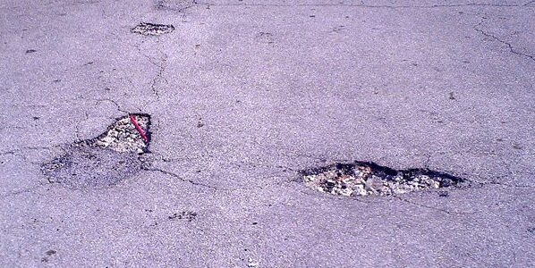A Concrete Floor With Two Potholes