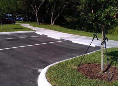 A White Color Curb With Grass and Markings